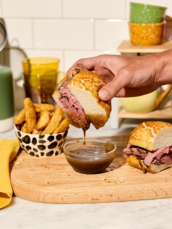 Dipping a Dutch Crunch Sando in sauce